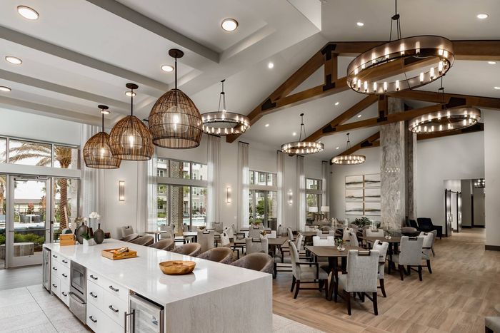 Resident lounge and dining area at our senior living community in Winter Garden, FL, featuring wood grain floor paneling.