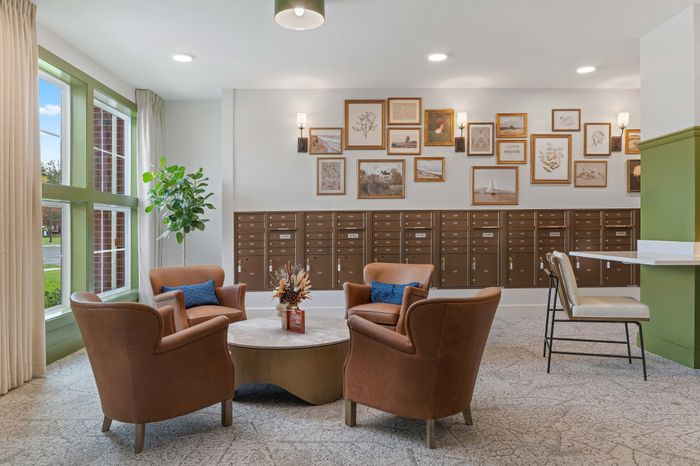 Chic lobby area with cozy leather seating, elegant wall art, and a vibrant indoor plant, creating a warm and inviting atmosphere.
