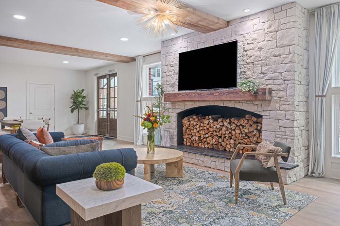 Charming living room with stone fireplace, cozy seating, and elegant decor bathed in natural light.
