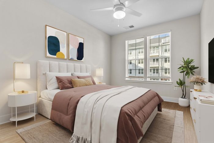 Inviting bedroom with a large sunlit window, elegant decor, and cozy bedding, exuding a serene and modern ambiance.