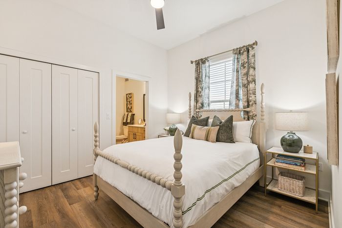 Inviting bedroom with elegant four-poster bed, soft lighting, and stylish decor, featuring hardwood floors and an en-suite bathroom.