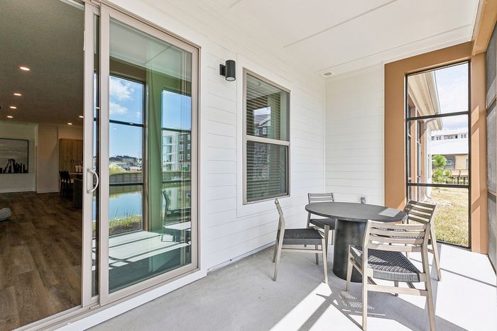 Charming outdoor patio with modern furniture, offering a serene view of the water from a stylish apartment.