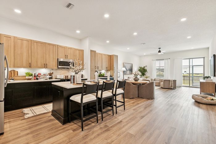 Modern open-concept apartment with stylish kitchen and spacious living area featuring elegant wood cabinetry and contemporary furnishings.