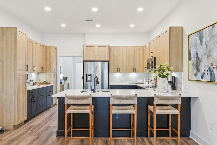 Contemporary kitchen with sleek cabinetry, stainless steel appliances, and a stylish breakfast bar with plush seating.