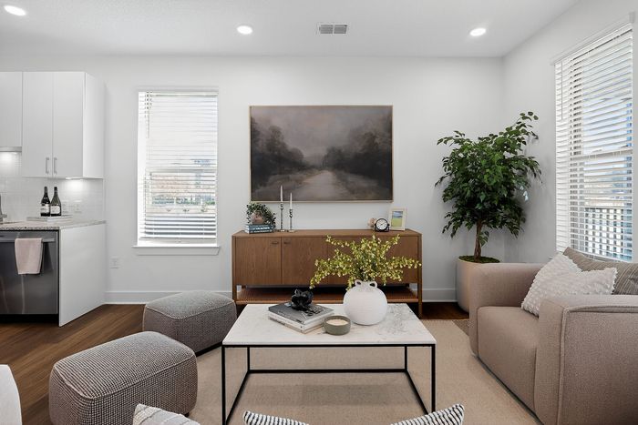 Contemporary living room featuring elegant decor, cozy seating, and abundant natural light with lush greenery.