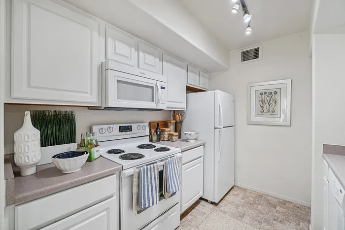 Bright and inviting kitchen with modern white cabinetry, sleek appliances, and stylish decor accents.