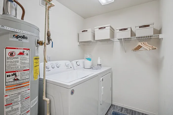 Modern laundry room with a sleek washer and dryer set, ample shelving, and storage options for a clutter-free lifestyle.