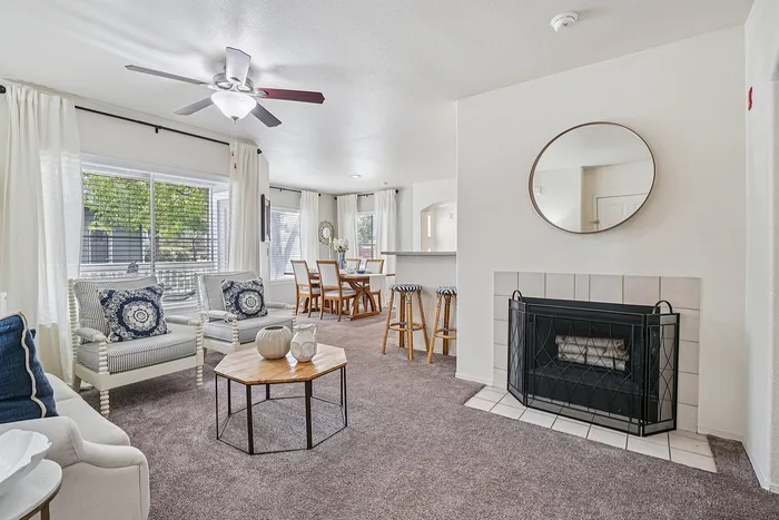 Bright and inviting open living space with modern furniture, elegant fireplace, and a dining area perfect for gatherings.