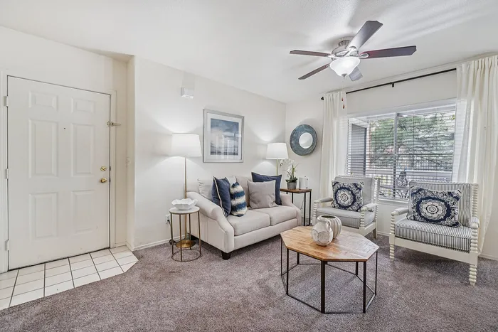 Inviting living room with elegant sofa, stylish armchairs, and a modern coffee table, highlighted by natural light and contemporary decor.