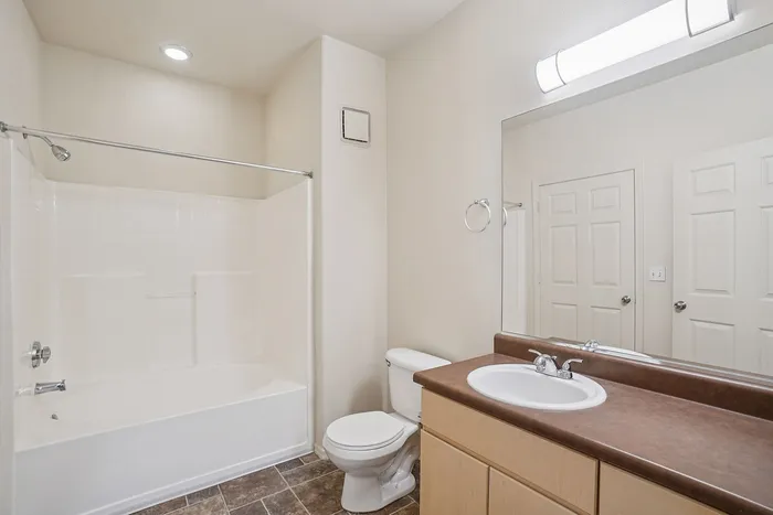 Modern bathroom featuring a sleek bathtub, elegant sink, and stylish tile flooring under soft ambient lighting.