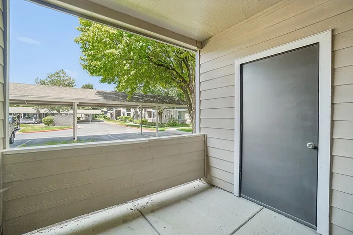 Charming patio view showcasing a cozy outdoor space with tree-lined surroundings, offering tranquility and privacy.