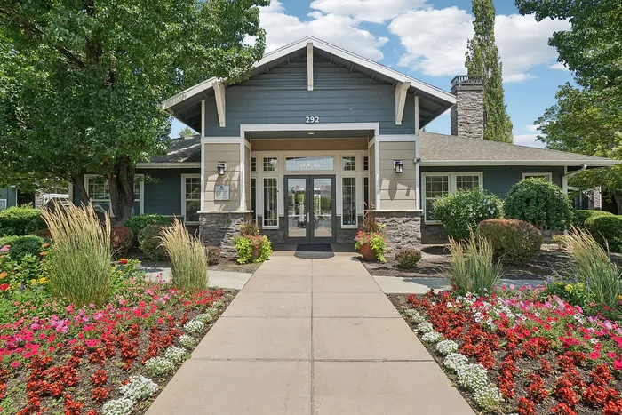 Charming residential entrance with vibrant flower beds and modern architectural design, welcoming you to serene living.