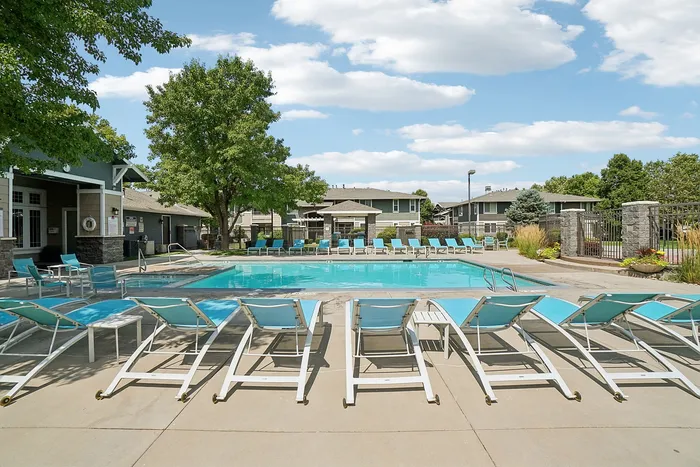 Inviting outdoor pool area with comfortable lounges and vibrant greenery, perfect for relaxation and enjoyment.