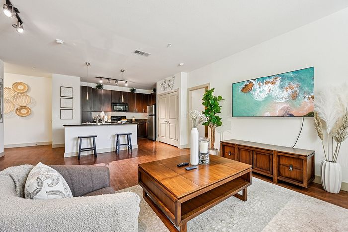 Inviting modern living room with open-concept kitchen, cozy seating, and stylish decor, perfect for relaxation and entertaining.