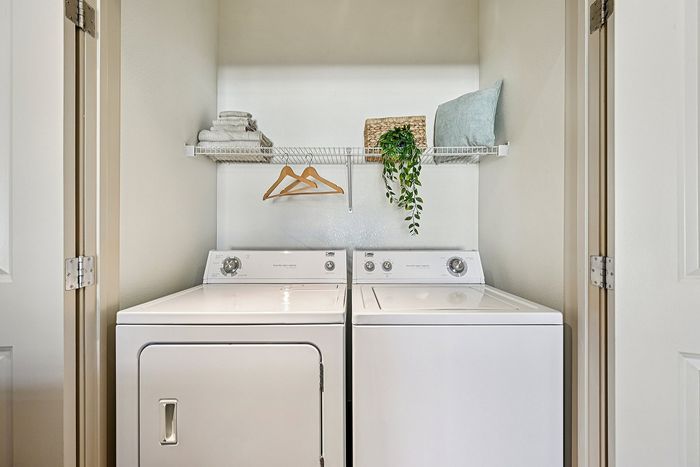 Elegant apartment laundry nook featuring modern appliances, organized shelving, and stylish decor for efficient living.