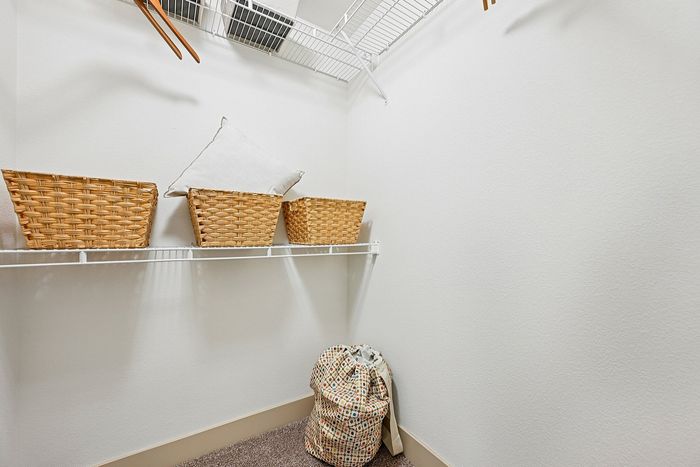 Spacious walk-in closet with organized wicker baskets and ample shelving.