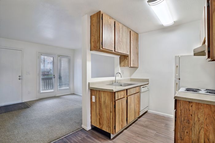 Charming apartment kitchen with modern appliances, and bright natural light from adjacent living room.