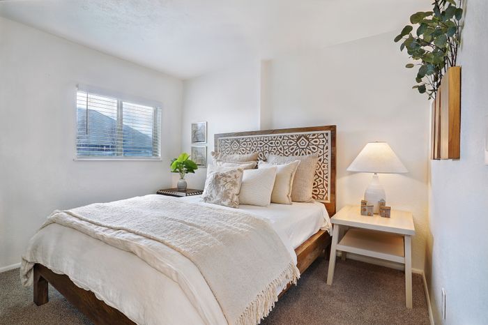 Inviting bedroom with a cozy bed and soft, natural light streaming through the window.