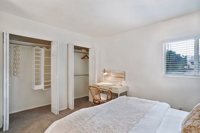 Bright and cozy bedroom featuring ample closet space and a picturesque window view.