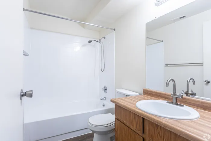 Bright and modern bathroom featuring a sleek bathtub, elegant faucet, and stylish wood vanity.