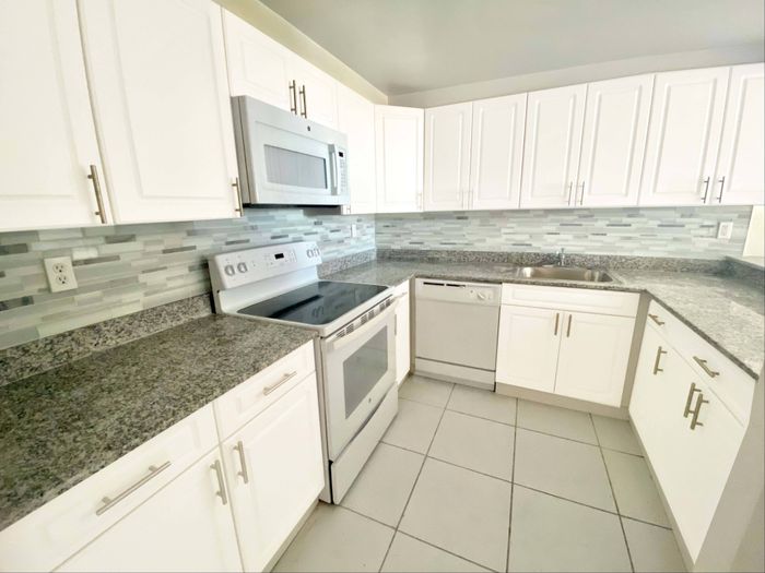 2500 Inverrary Club Apartments, kitchen, granite countertops, white cabinetry, microwave, oven, dishwasher, stovetop