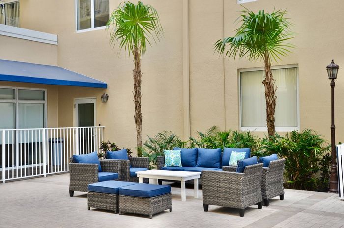 Miami Riverfront Residences, exterior, sparkling blue swimming pool, lounge chairs, balconies on building
