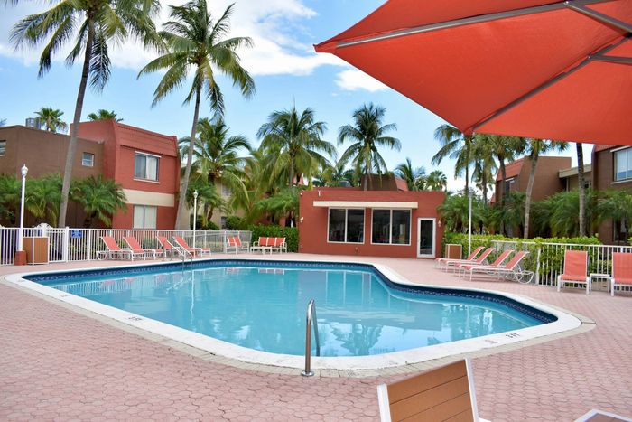 Cherry Grove Village, exterior, sparkling blue pool, palm trees, clubhouse