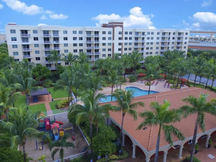 Royal Palms Apartments, exterior, aerial view of property, sparkling blue pool, palm trees, clubhouse, playground equipment
