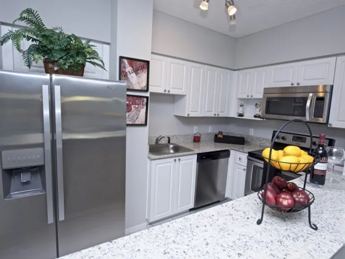 Royal Palms Apartments, interior, kitchen, white cabinets, stainless steel appliances, refrigerator, stove/oven, microwave, dishwasher, breakfast bar counter,