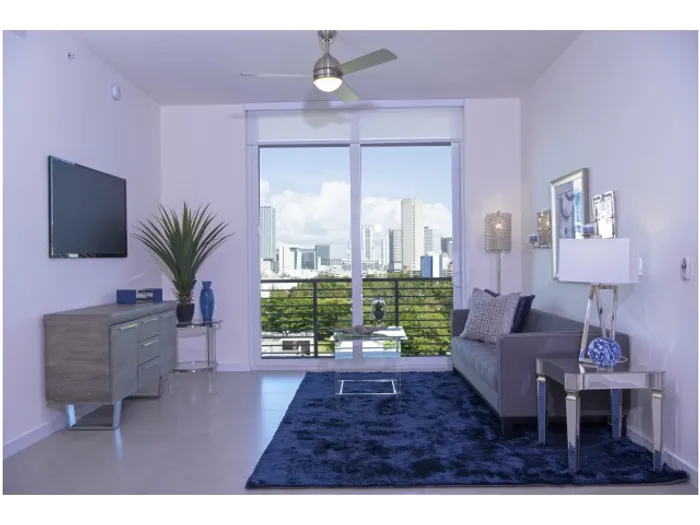 Brickell West City Rentals Interior | Living room | Couch | TV | Balcony door | View of city