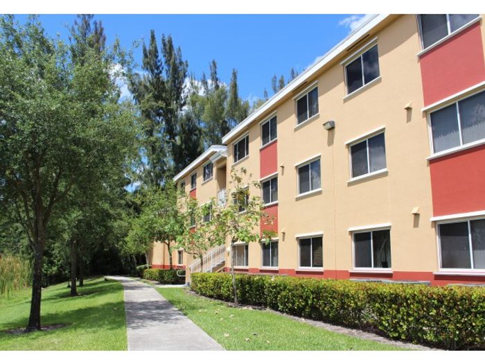 Sunshine Lakes Exterior | Beige building | Sidewalk up to building | Green lawn