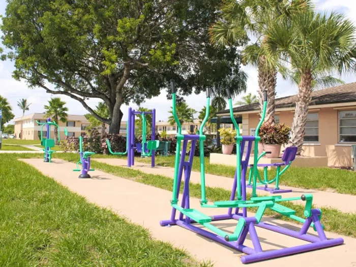 Pompano Palms Apartments, exterior, outdoor exercise equipment, trees, grass