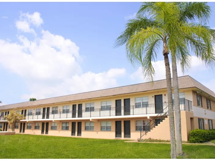 Pompano Palms Apartments, building exterior, two levels, palm trees, grass