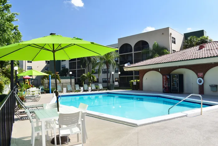 Royalton on The Green Exterior | Outdoor pool beside building | Vending machines | Pool chairs
