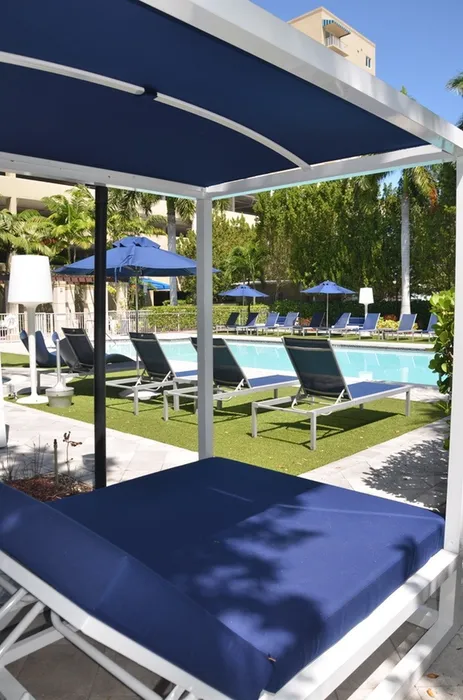Gables 37 Grand, exterior, sparkling blue pool, palm trees, lounge chairs, playground equipment