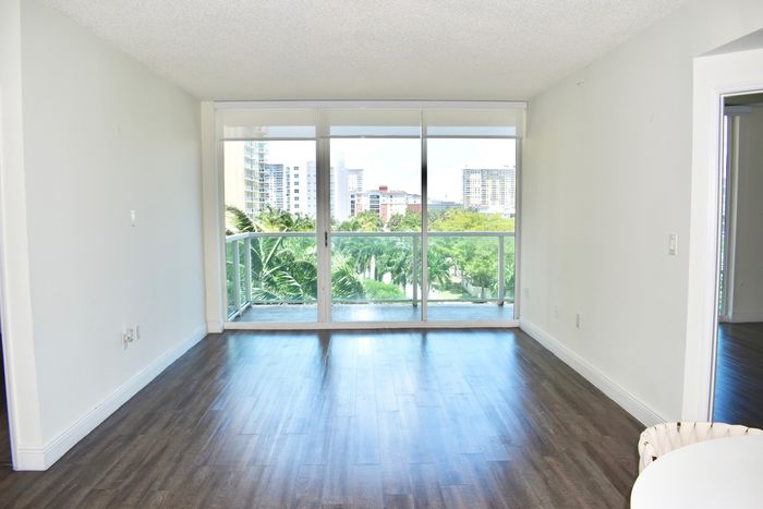 Intracoastal Yacht Club, interior, spacious open concept, kitchen, dining, living room, large sliding glass door to balcony, stainless steel appliances, dishwasher, stove/oven, tiled flooring