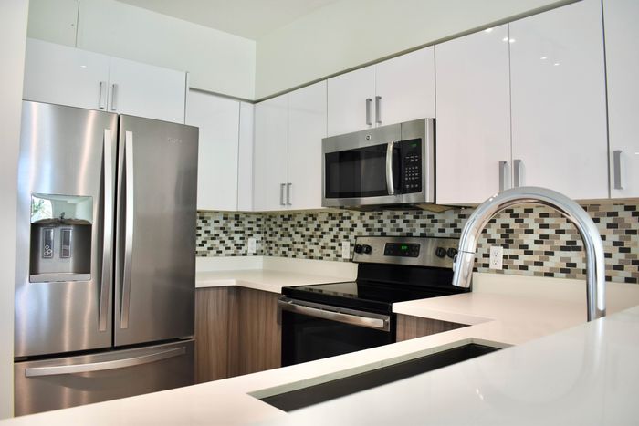 Miami Bay Waterfront Midtown Residences, interior, spacious kitchen, white and brown cabinets, stainless steel appliances, refrigerator, microwave, stove/oven, dishwasher