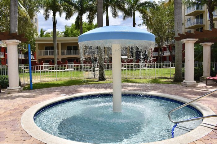 Country Club Towers, exterior, kiddie pool with water fall, palm trees, lounge chairs, pergola