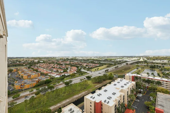 Breathtaking aerial view from an apartment showcasing lush landscapes, cityscape, and expansive blue skies.