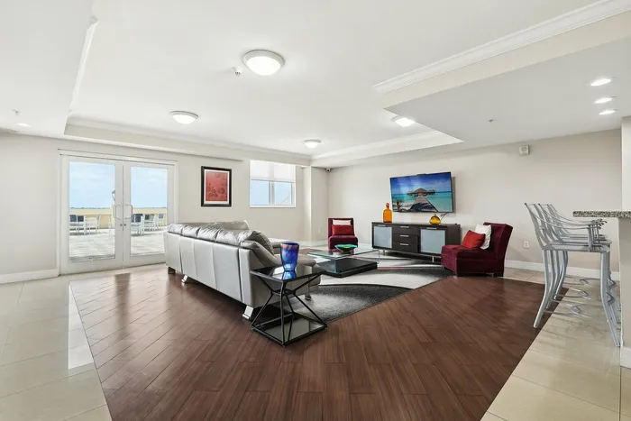 Bright and spacious modern living room with sleek furniture, a stylish entertainment center, and access to an inviting outdoor patio.