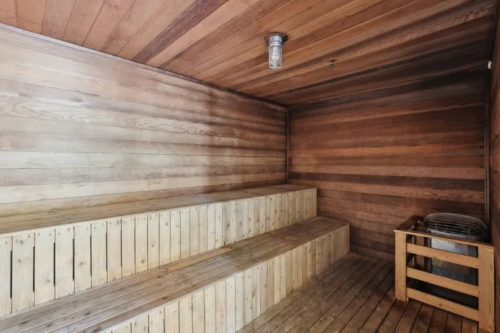 Inviting wooden sauna with warm wooden interiors and tiered seating, perfect for relaxation and unwinding.
