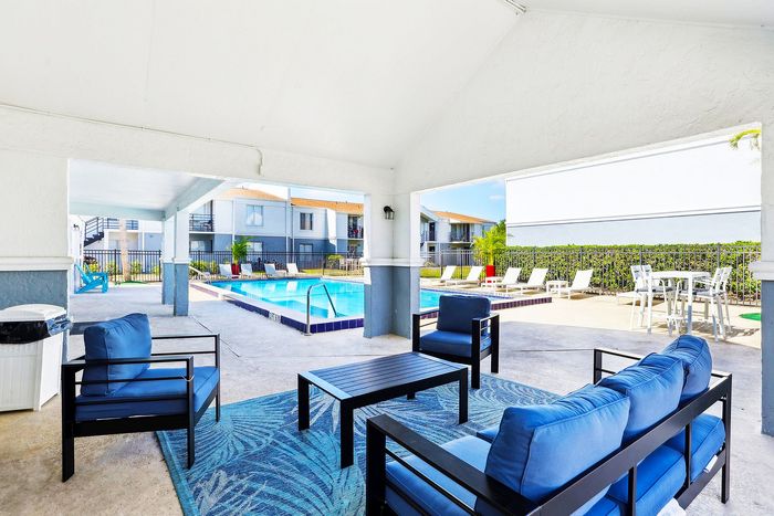 Charming outdoor seating area beside a sparkling pool, perfect for relaxation and enjoying sunny days.