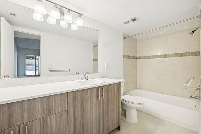 Bright and modern bathroom with sleek fixtures, elegant lighting, and a spacious vanity.