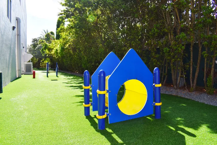 Vibrant playground with colorful structures on lush green turf, perfect for children's playtime and outdoor fun.