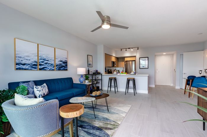 Modern open-concept living room with elegant decor and stylish kitchen peninsula.