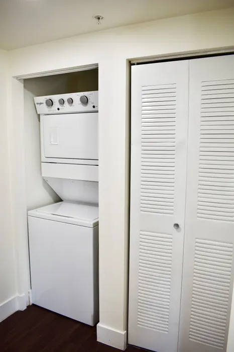 Compact laundry alcove with modern stacked washer and dryer, perfect for maximizing apartment space.