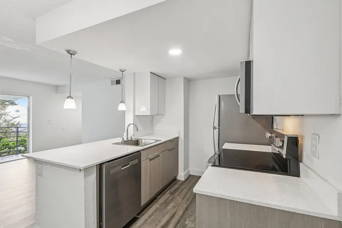 Modern kitchen with sleek stainless steel appliances, elegant pendant lighting, and a stylish open-concept design.