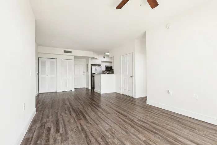 Bright and modern apartment with sleek hardwood flooring, open-concept layout, and stylish kitchen with stainless steel appliances.