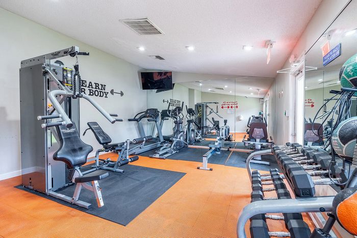 Bright and modern gym featuring state-of-the-art exercise equipment, mirrored walls, and motivational fitness decor.