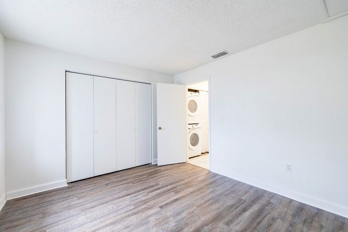 Bright, spacious apartment bedroom with sleek hardwood floors and convenient in-unit laundry.